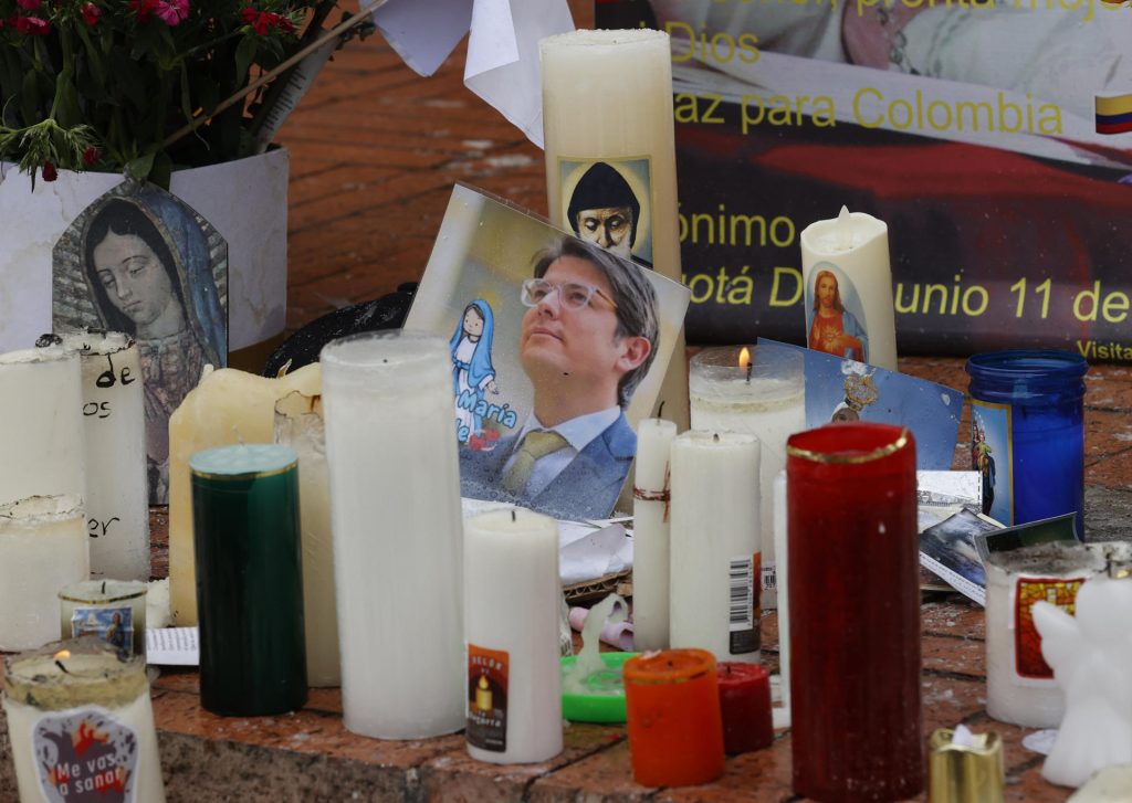 Fotografía de una imagen del senador Miguel Uribe en medio de velas puestas en un altar frente al hospital Fundación Santa Fe de Bogotá, este sábado en Bogotá (Colombia). EFE/ Mauricio Dueñas Castañeda
