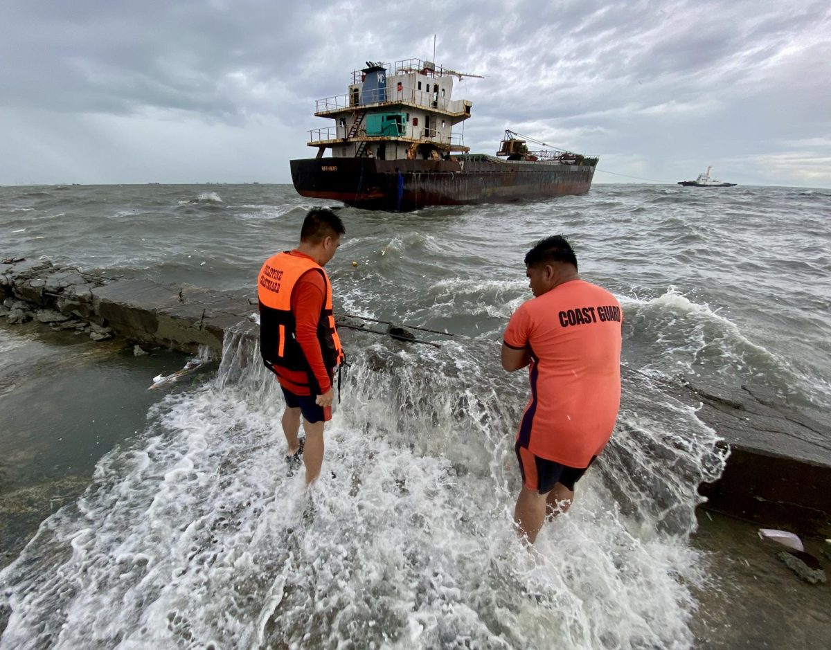 NAVOTAS CITY (Philippines), 25/07/2025.- Filipino coastguard personnel view a run-aground cargo ship in Navotas city, Metro Manila, Philippines, 25 July 2025. The Philippine National Disaster Risk Reduction and Management Council (NDRRMC) reported on 25 July that the death toll from the combined effects of over a week of storms was recorded at 25 and more than a million families are affected as Tropical Storm Co-May battered the northern part of main Philippine island, Luzon. (tormenta, Filipinas) EFE/EPA/FRANCIS R. MALASIG
