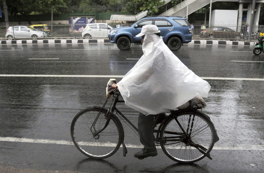 Un hombre en bicicleta bajo una intensa lluvia en Nueva Delhi. EFE/Str/Archivo