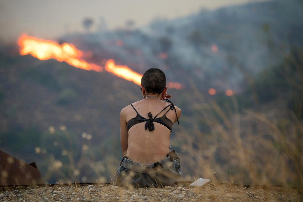 .- Imagen de este martes de una persona observa un incendio forestal en una zona montañosa entre Potamia y Pispilounta este martes, en la isla de Quíos (Grecia). EFE/EPA/ Kostas Kourgias