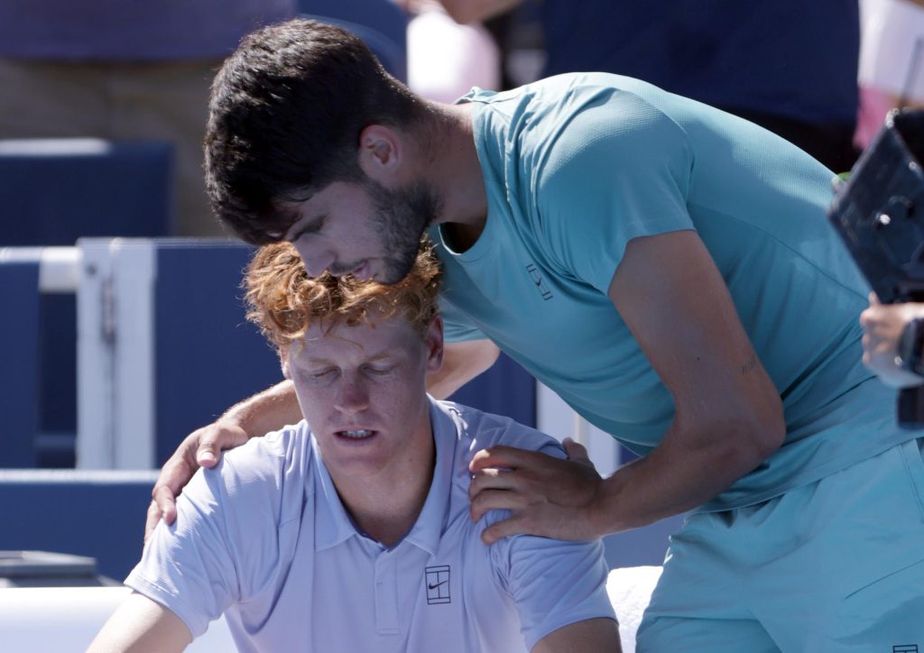 Carlos Alcaraz (d) consuela a Jannik Sinner, tras la retirada del italiano en la final del Abierto de Cincinnati. EFE/EPA/MARK LYONS