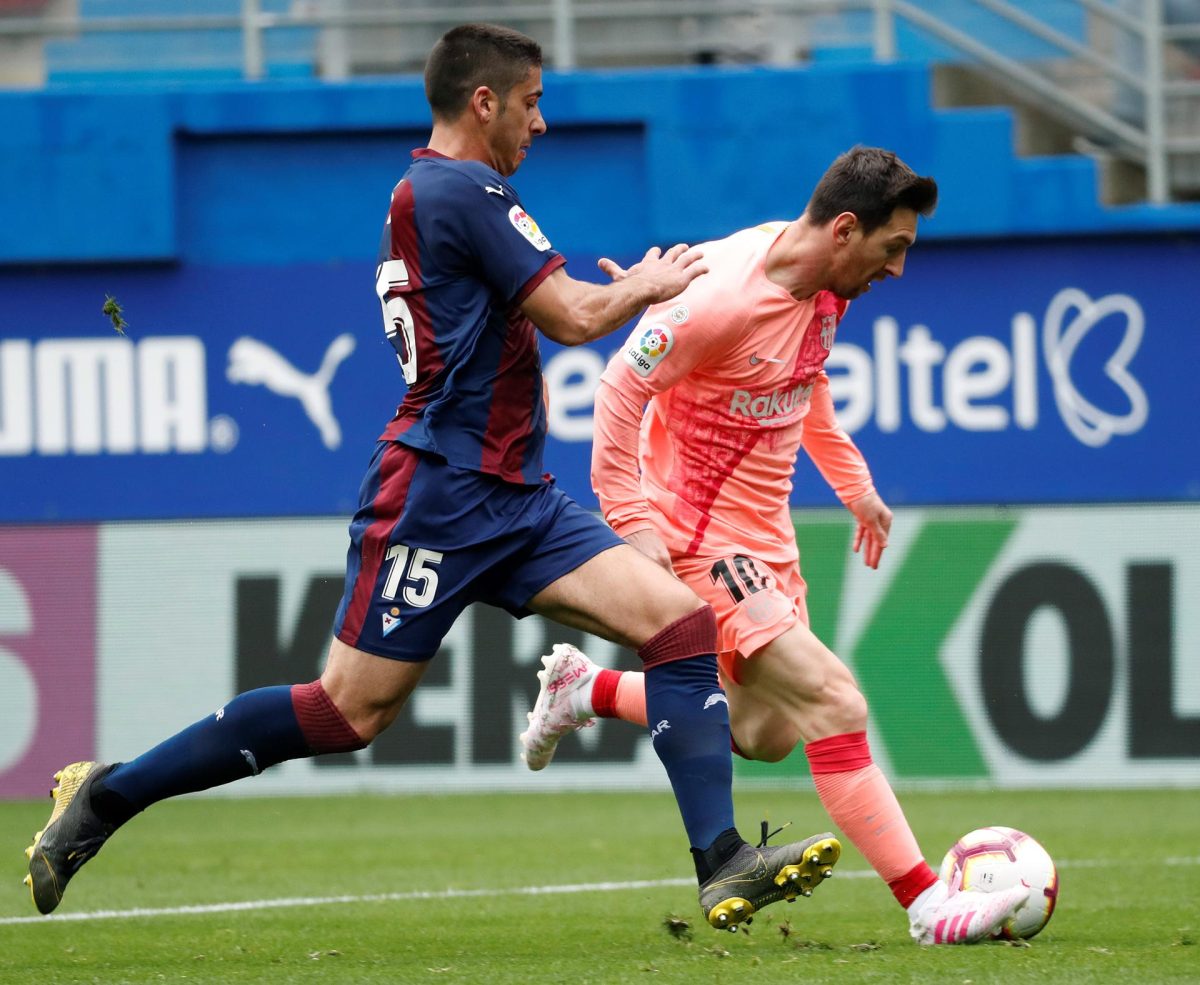José Ángel Valdés "Cote" (i), trata de cortar una jugada de Lionel Messi, durante el partido de la Liga disputado entre el Eibar y el Barcelona en el estadio de Ipurúa, el 19 de mayo de 2019. EFE/ Juan Herrero
