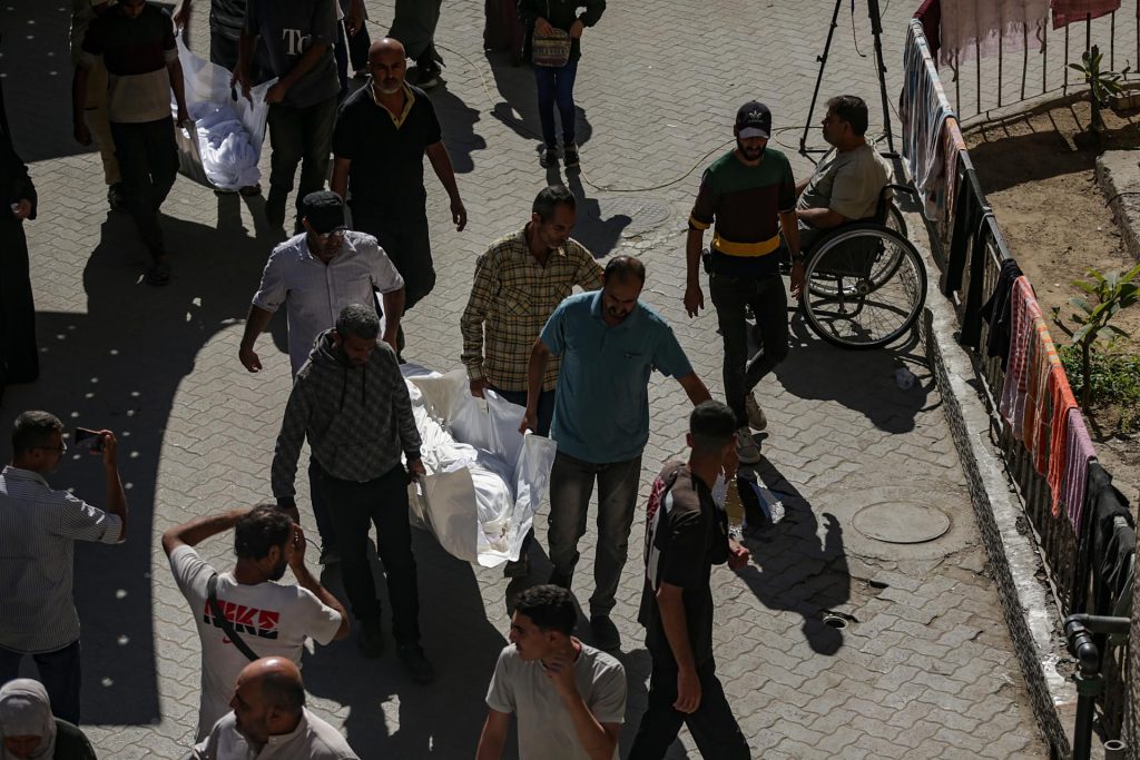 Un grupo de palestinos fue captado este sábado, 18 de octubre, al llevar el cuerpo de un miembro de la familia Abu Shaban al Hospital Bautista Al Ahli, en la ciudad de Gaza (Palestina). EFE/Mohammed Saber
