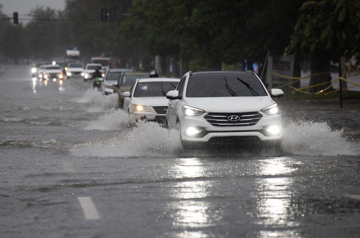 Personas se movilizan en vehículos por una avenida inundada este viernes, en Santo Domingo (República Dominicana). EFE/Orlando Barría
