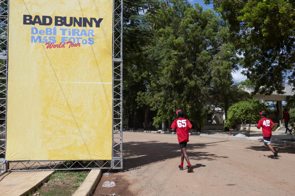 Personas pasan frente a una valla publicitaria previo al concierto del cantante puertorriqueño Bad Bunny, este jueves, en Santo Domingo (República Dominicana). EFE/ Orlando Barría
