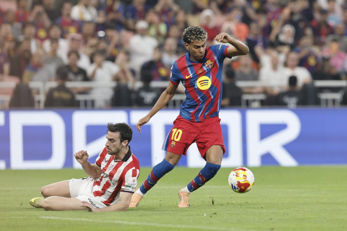 El delantero del FC Barcelona, Lamine Yamal (d), se lleva el balón ante el defensa del Athletic Club, Iñigo Lekue, durante el partido de la Supercopa de España que disputan el FC Barcelona y el Athletic Club, este miércoles en el estadio Alinma Bank Stadium at King Abdullah Sport, en Yeda. EFE/ Kai Forsterling 