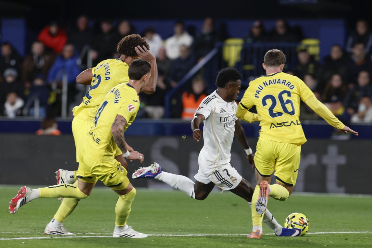 El delantero del Real Madrid Vinicius Jr. (2d) centra el balón junto a Pau Navarro, del Villarreal, durante el partido de la jornada 21 de LaLiga que Villarreal CF y Real Madrid disputan en el estadio de La Cerámica. EFE/Kai Forsterling 