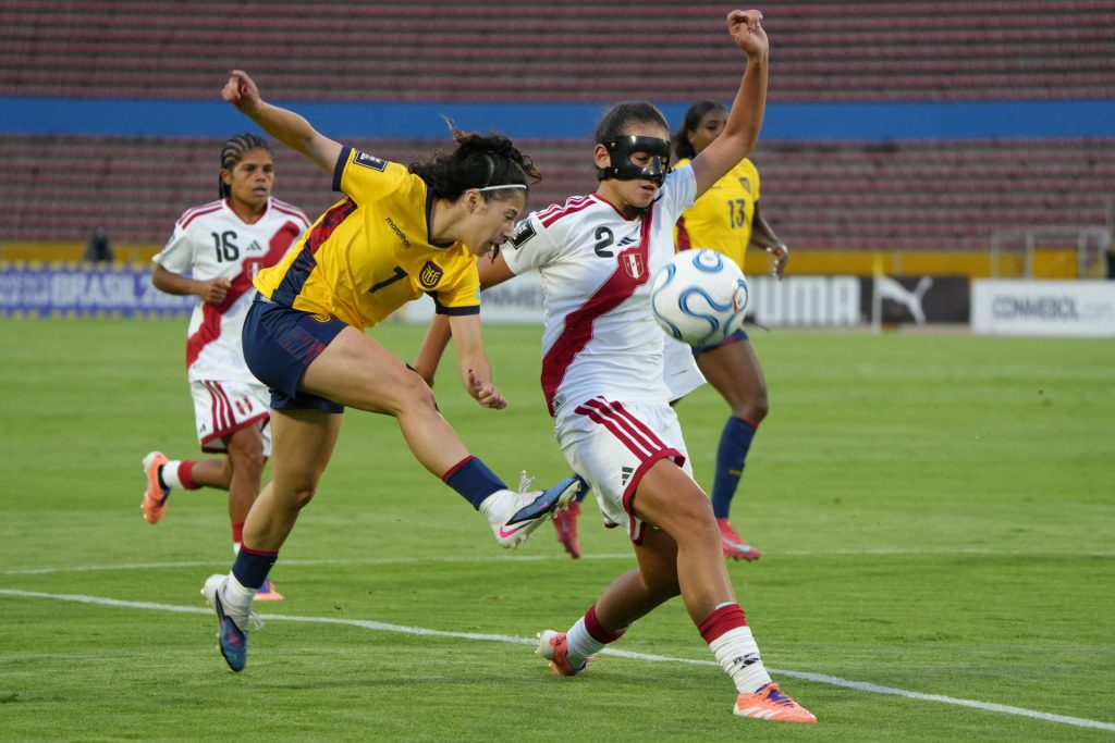 La ecuatoriana Emily Arias (i) prueba con un remate a la portería de Perú ante la marca de Luana Chamochumbi en el partido de la Liga de Naciones jugado este sábado en el estadio Olímpico Atahualpa en Quito. EFE/ Vicente Costales 