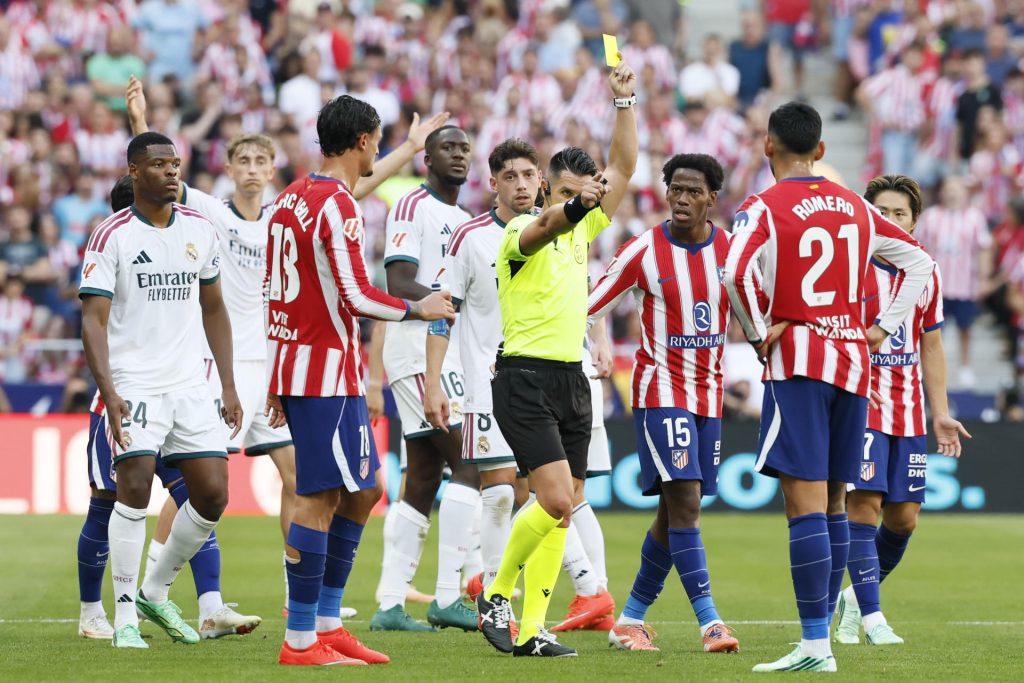 El árbitro Miguel Ángel Ortiz saca tarjeta amarilla al jugador del Atlético de Madrid Cuti Romero (d) durante el partido de LaLiga EA Sports entre Atlético de Madrid y Real Madrid celebrado en el del estadio Riyadh Air Metropolitano de la capital española. EFE/ Ballesteros